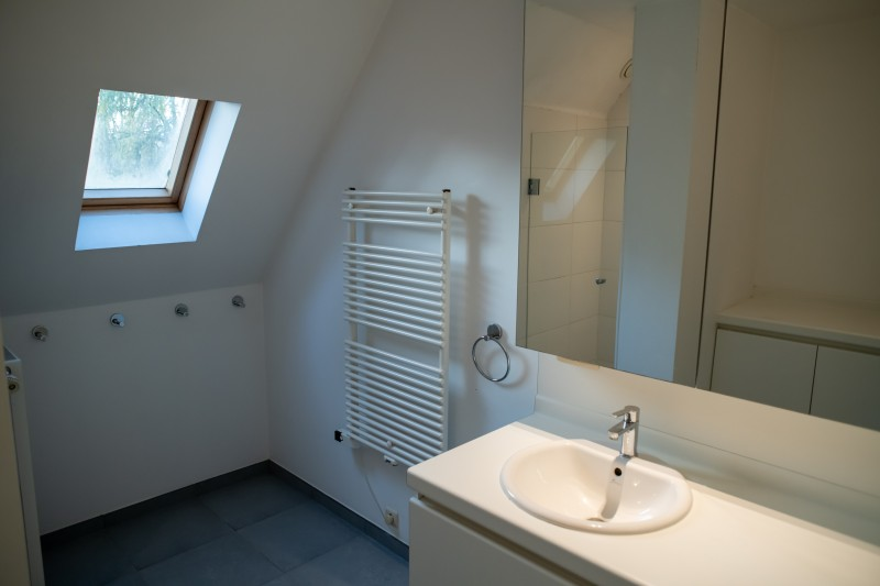 Zolderbadkamer met ronde spiegel en maatwerk — voor renovatie